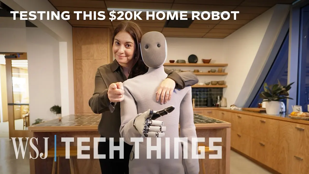 Joanna Stern is standing behind humanoid robot Neo with her arm around robot in the kitchen. Both are pointing at you.